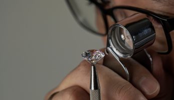 Man examining a diamond through magnifier